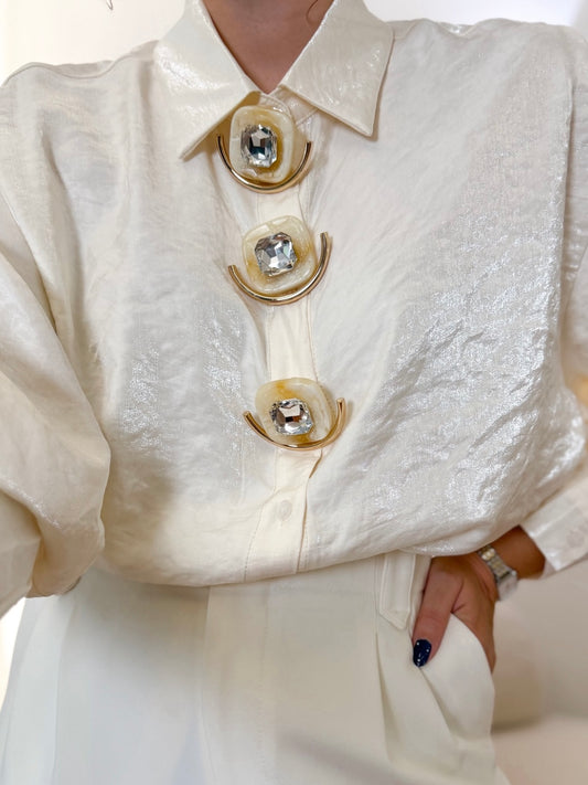 Blouse ivoire avec épingles amovibles.